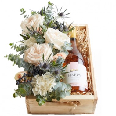 Caja con vino rosa y flores