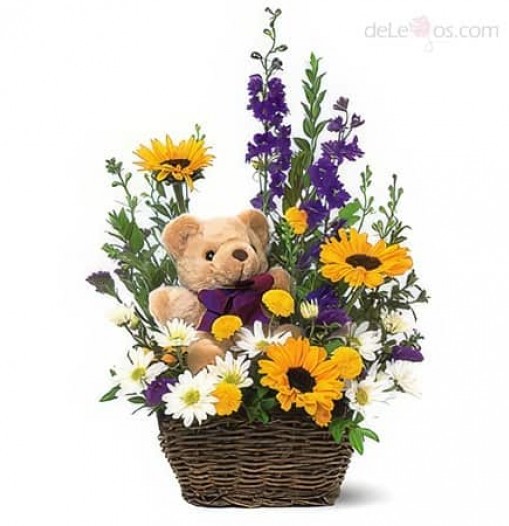 Canasta con flores primaverales y oso de peluche